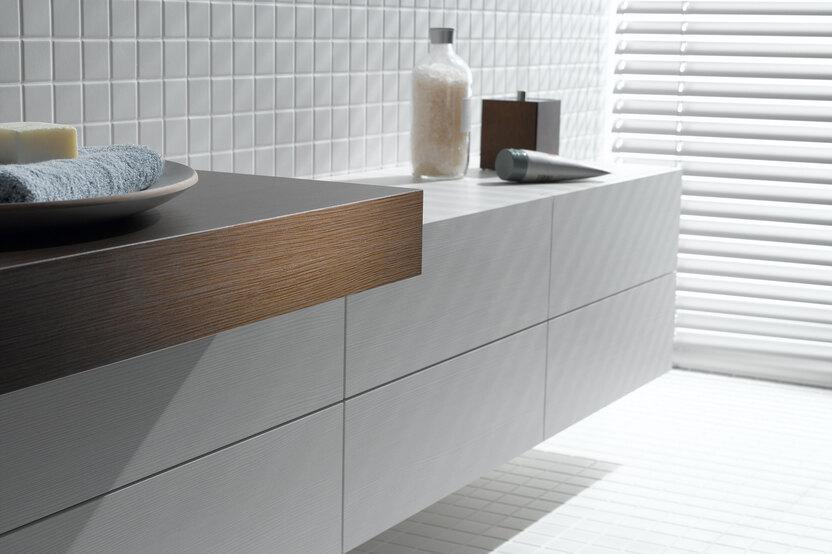 Detailaufnahme eines weißen Waschtischunterschrankes mit dunkler Waschtischplatte