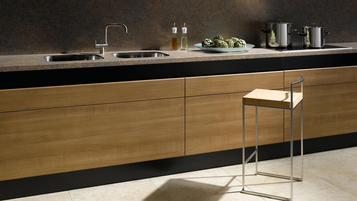 Küchenzeile aus Massivholz mit dunkler Arbeitsplatte Küchenzeile aus Massivholz mit schwarzer Arbeitsplatte, Spülbecken und Wandregal